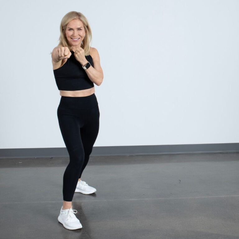 woman in workout clothes air punching in gym